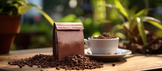 Unbranded coffee powder packaging cardboard and coffee beans on table, blur coffee garden background © Muhammad