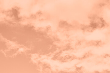 Peach Fuzz toned sky and clouds. Monochrome background 2024 color of the year.