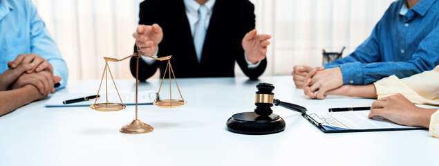 Focused gavel hammer and balance scale of justice on blurred background of lawyer acting as...
