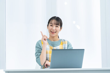 室内で指差しをする笑顔のエプロンをつけた保育士