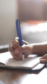 Close Up Of A Hand Writing In A Small Book Using Blue Pen In Vertical Video