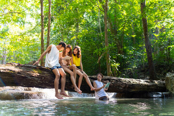 Group of Young Asian man and woman enjoy and fun outdoor lifestyle travel nature forest mountain on summer holiday vacation. Happy generation z people friends playing water together at waterfall.