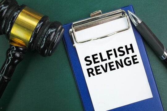judge's gavel, pen and paper board with the word selfish revenge. the concept of revenge