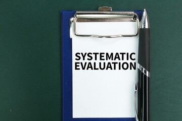 pen and paper board with the word systematic evaluation. the concept of systematic evaluation