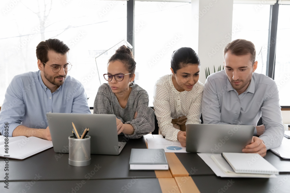 Canvas Prints serious multiracial employees look at laptop screen work together on gadgets at office meeting. conc