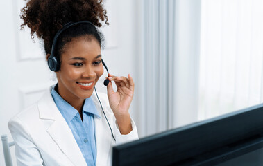African American young businesswoman wearing headset working in office to support remote crucial...