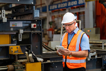 Caucasian industrial worker is using digital tablet to take note while inspecting inside the metal...