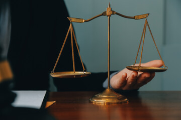 Business and lawyers discussing contract papers with brass scale on desk in office. Law, legal services, advice, justice and law concept picture with film grain effect