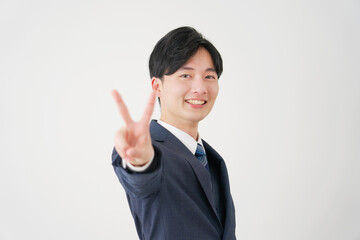 ピースサインをするビジネスマン　白背景