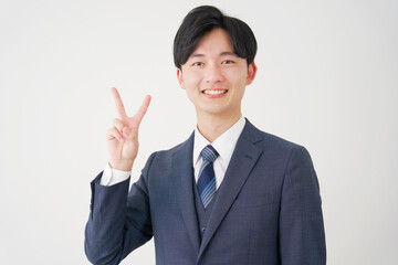 ピースサインをするビジネスマン　白背景
