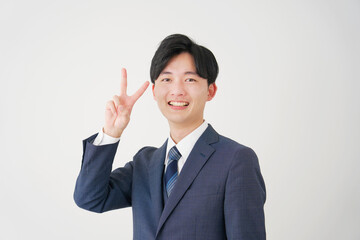 ピースサインをするビジネスマン　白背景