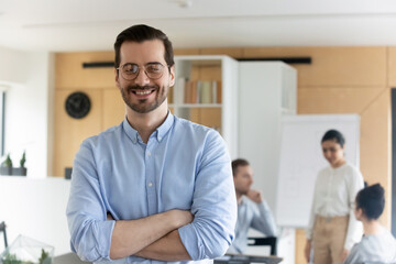 Portrait of smiling successful Caucasian male employee in glasses feel optimistic excited at...