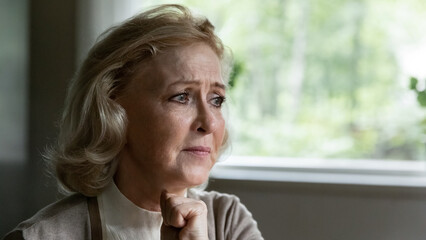 Pain in eyes. Lost upset middle age female retiree sit by window suffer of loneliness depression...