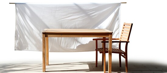 Obraz na płótnie Canvas White tarpaulin shades the wooden table and chair from the sun and rain.