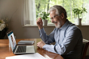 Telemedicine. Energetic smiling elderly man grandfather having virtual consultation online with...