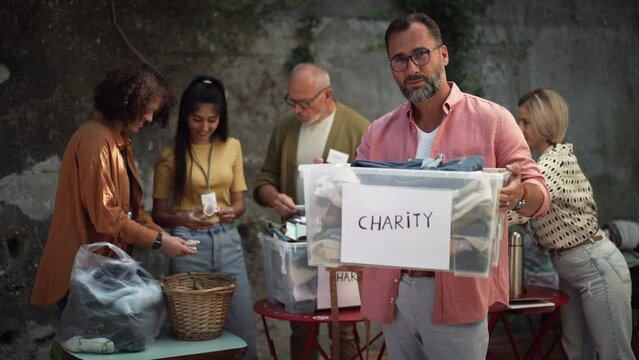 Volunteers sorting of clothes collected in a charity. Charitable work concept.