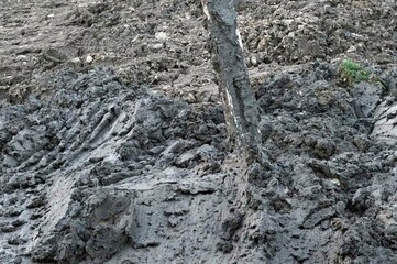 Mud and mud in the field as a background with cement pillar at construction site.