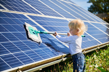 Little kid learning how to clean solar panel. Young boy learning how to care about solar station....