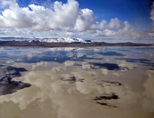 a lake, mountains, snow and clouds reflection