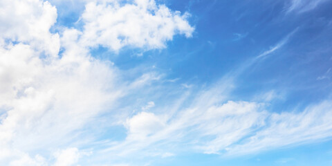 Soft and fluffy clouds formation on the bright sunny blue sky. Nature abstract background. Fresh air, weather and freedom concept. Banner for website.