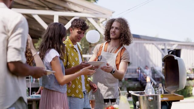 Friends and family talking and having fun at a summer grill garden party.