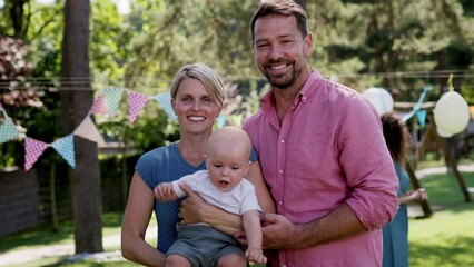 Young family with a baby at a family garden party.