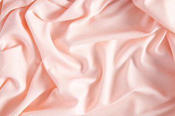 Luxurious satin textiles in peach color. Soft abstract waves of factory fabric. Festive background. Trend Colors of the Year 2024 Peach Fuzz.