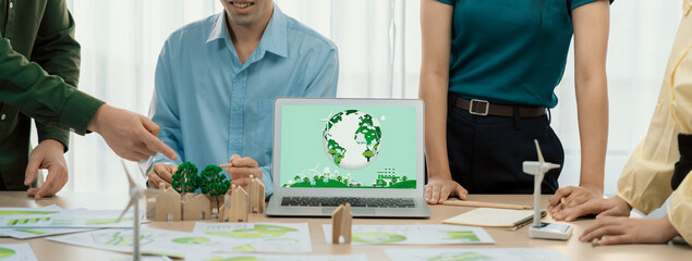 Green city logo displayed on a laptop at a green business meeting. Team presenting green design to...