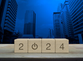 2024 start up business icon on wood block cubes on wooden table over modern office city tower and skyscraper, Happy new year 2024 success concept