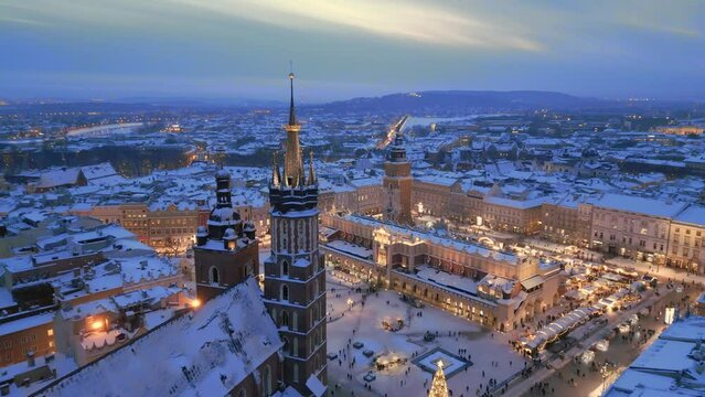 Krakow winter Main Market Square covered with snow aerial drone view of monuments - Saint Mary Church, Sukiennice (Cloth Hall), City Hall Tower, Wawel