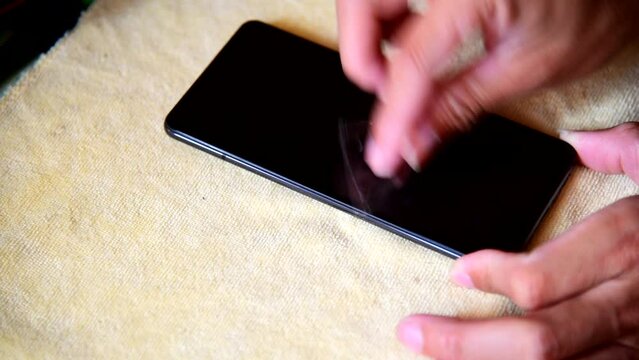 cleaning mobile phone screen by adhesive clear tape. Before apply the smart phone screen protect flim