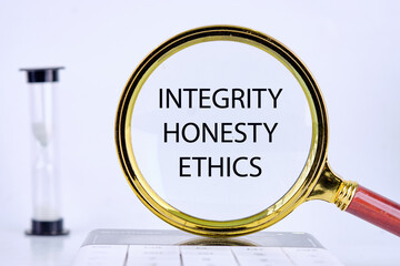 INTEGRITY HONESTY ETHICS text, word, inscription found through a magnifying glass next to an...