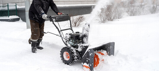 The janitor cleans the snow with a snow plow