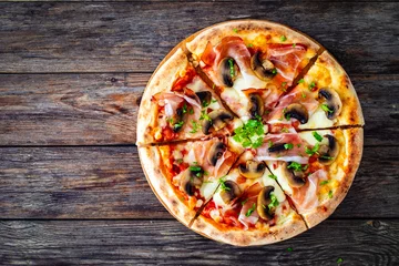 Fototapeten Top view of pizza speck with ham, mozzarella cheese and white mushrooms on wooden table  © Jacek Chabraszewski
