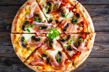 Top view of pizza speck with ham, mozzarella cheese and white mushrooms on wooden table  - obrazy, fototapety, plakaty