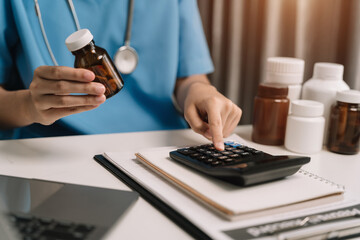 Doctors use a service fee calculator to save money on health insurance, drug cost concepts. - obrazy, fototapety, plakaty