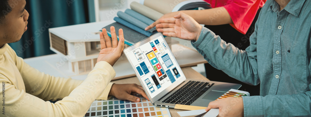 Poster cropped image of interior designer team presents color by using color swatches while laptop displaye