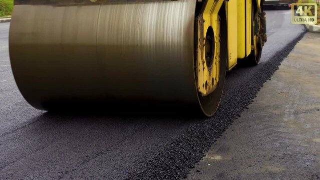The process of road construction where an asphalt roller levels the fresh asphalt surface on a new road.