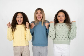 beautiful multiracial kid girls  celebrating surprised and amazed for success with arms raised and...