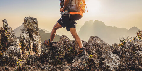 Hiker with backpack walking on top mountain sunset background. Hiker men's hiking living healthy active lifestyle. - obrazy, fototapety, plakaty