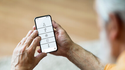 Senior man at home using medical app on smartphone