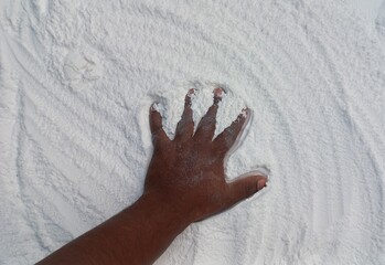 Snow-Covered Hand in a Blizzard. Frosty hand braving snowy blizzard with falling snowflakes.