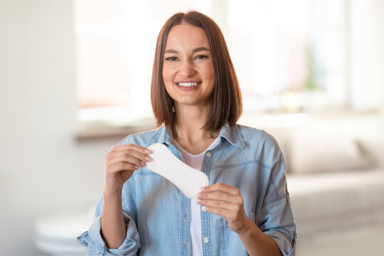Happy young woman holds daily cotton pad posing at home