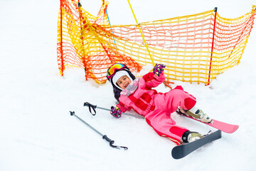 Fototapeta na wymiar Child skiing in mountains. Active toddler kid with safety helmet, goggles. Winter sport for family.