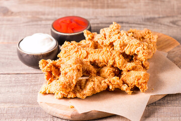 Crispy fried chicken breast strips with sauce