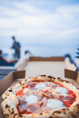 Italian Pizza Margherita with parma ham and mozzarella cheese in box at beach club Thailand
