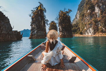 Traveler asian woman relax and travel on Thai longtail boat in Ratchaprapha Dam at Khao Sok National Park Surat Thani Thailand - 690956275