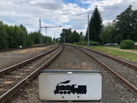 Train tracks and a sign with a picture of a train 