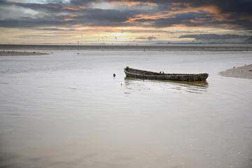 Foto auf Alu-Dibond Uitzicht over de Oosterschelde met op de voorgrond een gezonken boot begroeid met oesters, bij laagwater is de sloep zichtbaar boven de waterlijn. © ArieStormFotografie