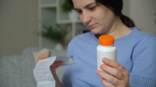 A woman reads the instructions for a medicine at home